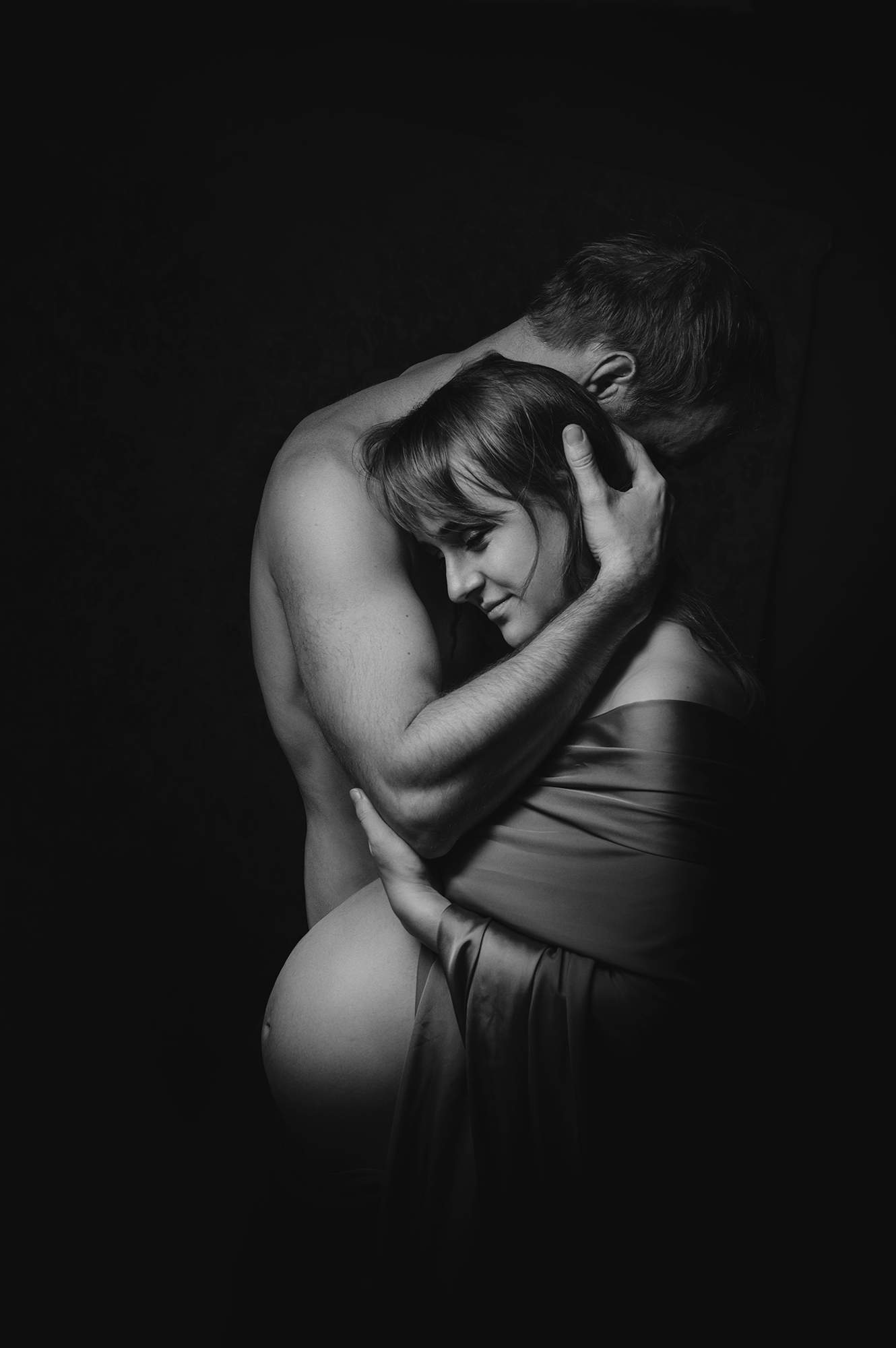 rodinné focení v ateliéru v Praze, těhotná maminka v láskyplném objetí partnerem. černobílá fotografie